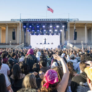 A crowd in front of a stage in front the CSUN Oviatt Library.