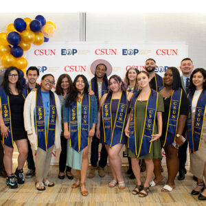 A group of students in EOP Resilient Scholars sashes and graduation gowns.
