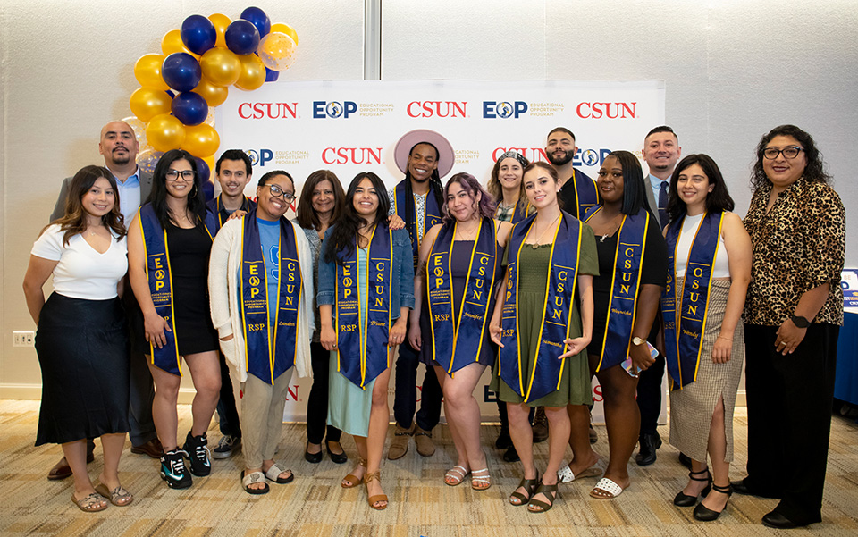 A group of students in EOP Resilient Scholars sashes and graduation gowns.