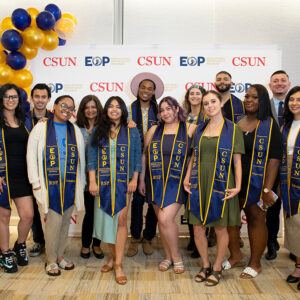 A group of students in EOP Resilient Scholars sashes and graduation gowns.