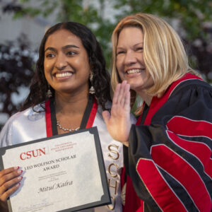Wolfson Scholar Mitul Kalra beams and holds certificate with CSUN President Erika D. Beck