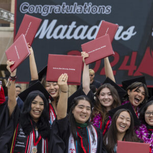 Students celebrate at a university commencement ceremony.
