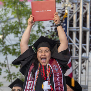 A student celebrates at a university commencement ceremony.
