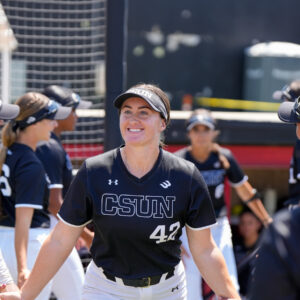 Shaylan Whatman smiles while high-fiving her teammates in Matador Diamond.