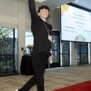 Kinesiology professor Paula Thomson strikes a dance pose and smiles at the Honored Faculty Awards reception.