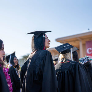 A female student in cap and gown in line for commencement.