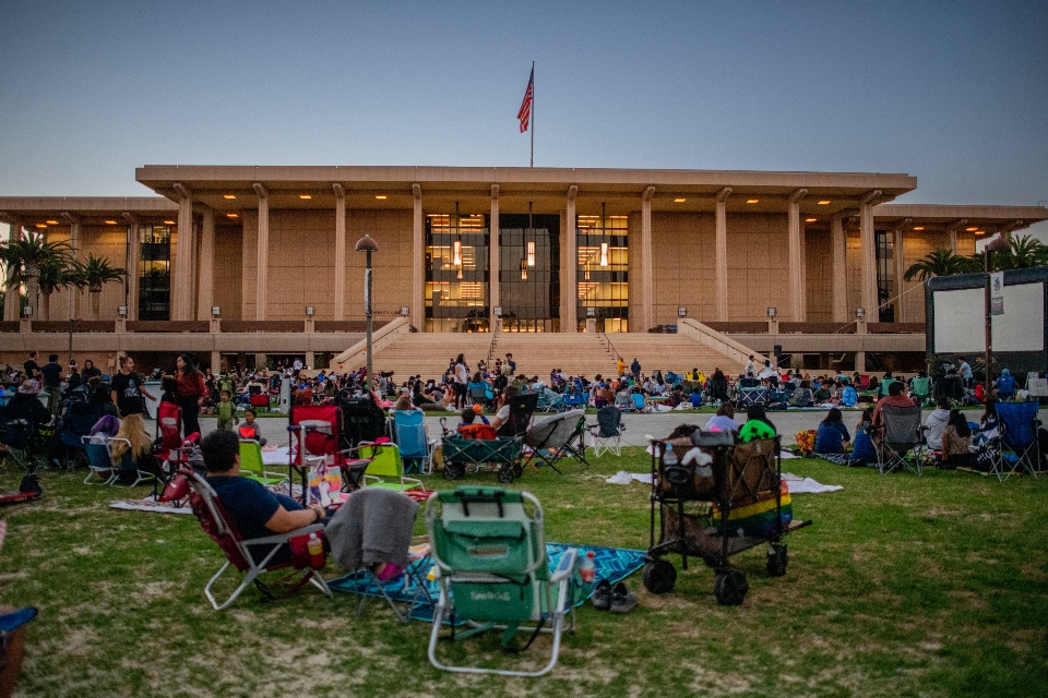 Crowds of people gathered in front of the University Library at CSUN at dusk to watch a movie at the Summer Movie Fest.