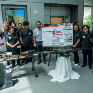 Students pose by their poster and their prototype