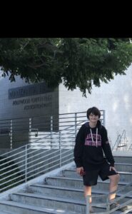 Tate Birchmore stands on the steps in front of Manzanita Hall.