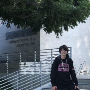 Tate Birchmore stands on the steps in front of Manzanita Hall.