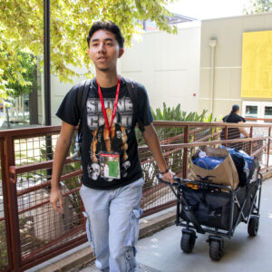 Jose Garcia pulls a wagon filled with items into his new dorm.