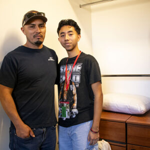 Jose Garcia poses for a photo with his dad inside his dorm room.
