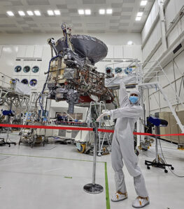 CSUN alumna Akemi Hinzer, in a full-body suit designed to prevent contamination, poses with the Europa Clipper spacecraft.