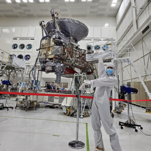 CSUN alumna Akemi Hinzer, in a full-body suit designed to prevent contamination, poses with the Europa Clipper spacecraft.