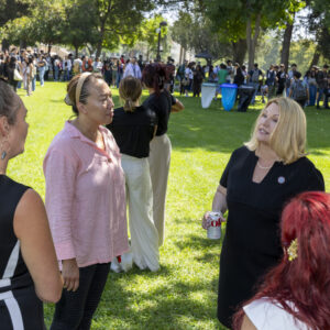 President Erika Beck talking to faculty and staff members in Bayramian Hall Lawn.