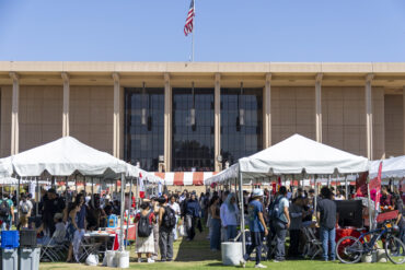 The University Library Lawn lined with rows of tents with tables and students.