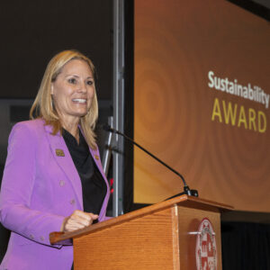 Nichole Ipach, vice president of University Relations and Advancement, standing at a podium presenting the Sustainability Award.