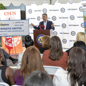 Congressman Tony Cárdenas stands at a podium in front of seated audience.