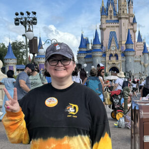 Maria Martinez stands in front of the castle at Disney World.
