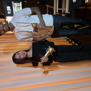 Ocampo and Rutledge smile for a picture backstage, each holding a Golden Globe award, at their Jan. 4 rehearsal.