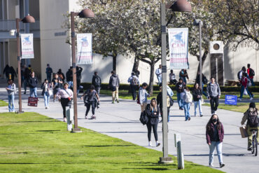 Students walk on campus near the University Library, spring 2024.