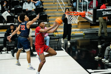CSUN basketball player Mahmoud Fofana, in a red jersey, goes for a layup in a victory over UC Davis on Feb. 22.