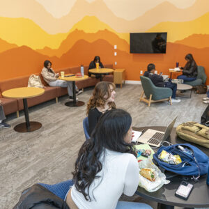 Students study in front of a colorful background in CSUN's Maple Hall.