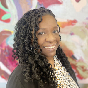 CSUN staff member Nicole Mills in front of a colorful background.