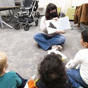 Children sit and listen to a story at Story Time in the University Library.