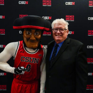 Bill Courtland and Matty the Matador smile for the camera in front of a CSUN Athletics backdrop ahead of a night of celebrations and reunions, setting the tone for an exciting evening.
