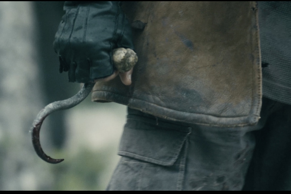Killer from the movie "Meathook" clenching a meathook in their fist