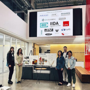 Students gathered around posters at design competition.