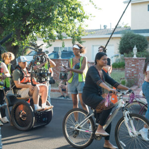 filming a scene for Moksha. 2 girls riding a bike.