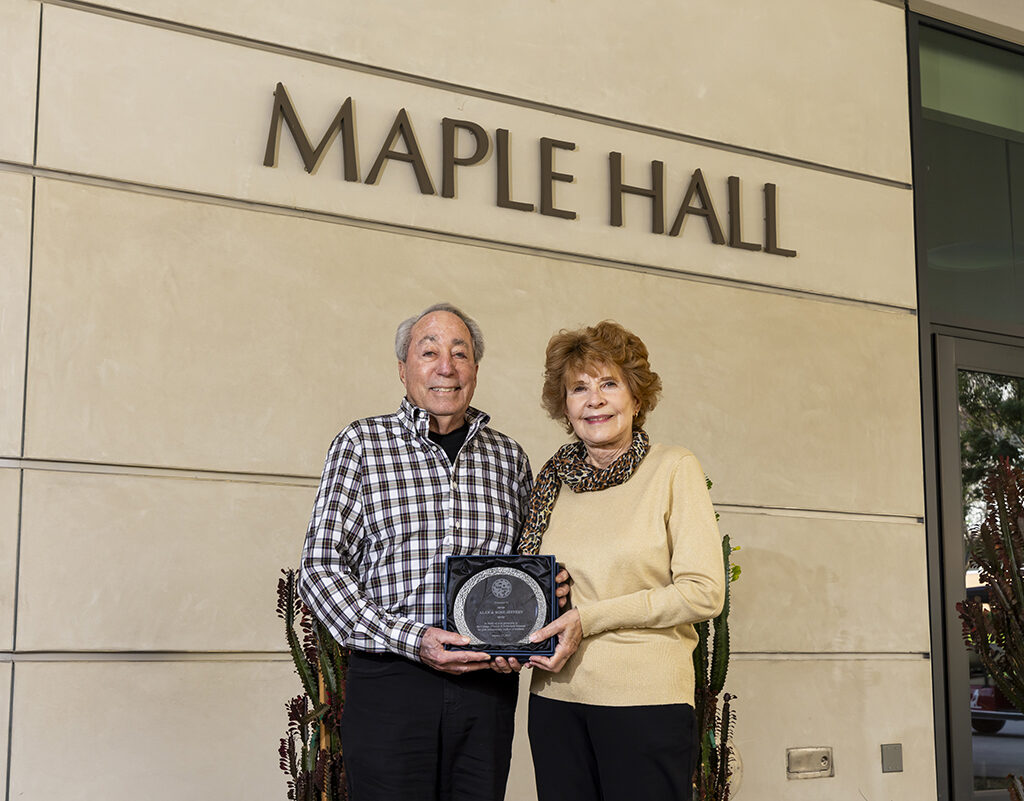 Alan and Rose Jeffery hold a plaque outside CSUN's Maple Hall.