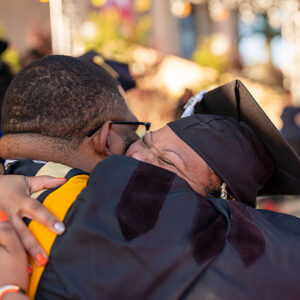 A graduate gives and receives a big hug.
