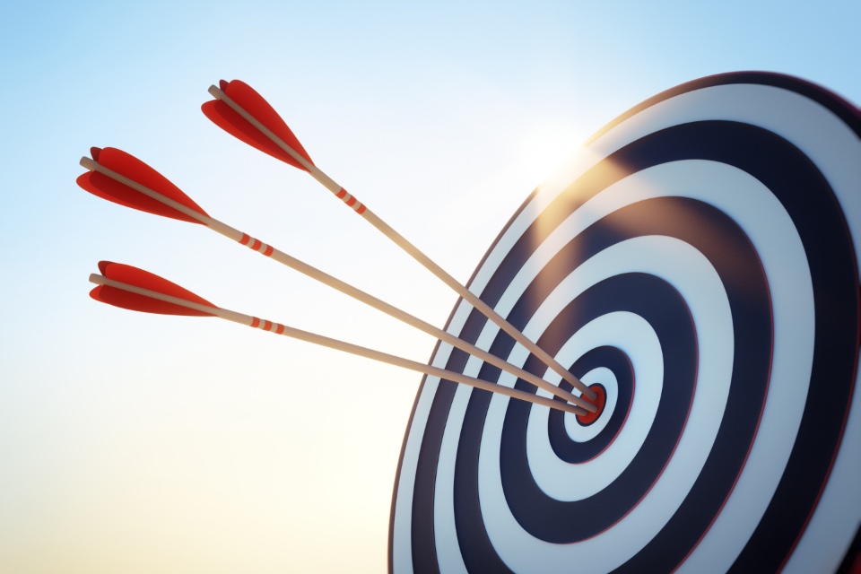 An archery target with three arrows within the bullseye range.