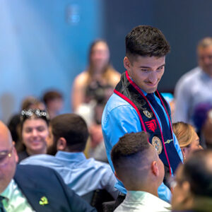 Graduate stands in the audience at the Veteran Graduation Celebration.