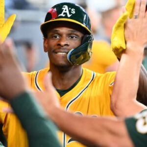 Former CSUN Baseball outfielder Denzel Clarke high-fives a group of teammates on the Athletics.