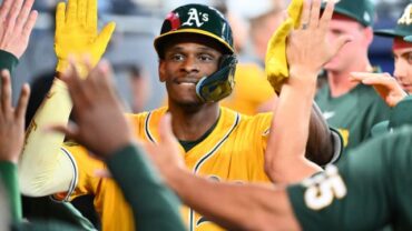 Former CSUN Baseball outfielder Denzel Clarke high-fives a group of teammates on the Athletics.