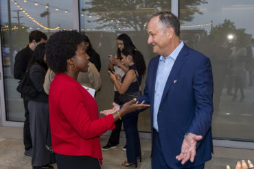 A woman has a conversation with former Second Gentleman Doug Emhoff at an event.