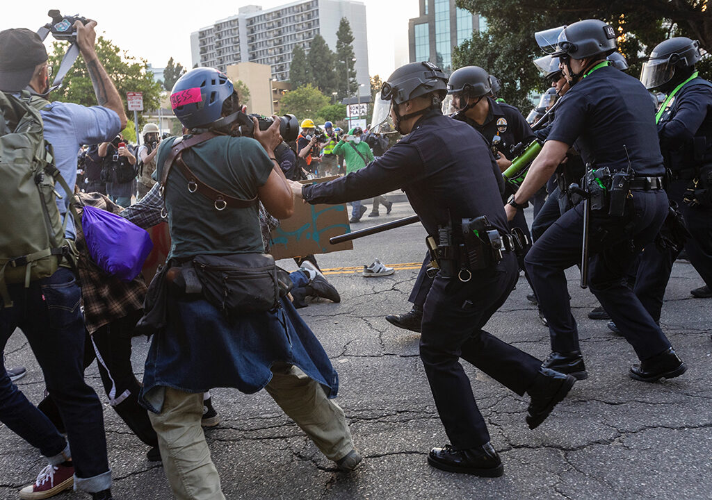 Photojournalists at work while police move on demonstrators.