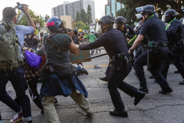 Photojournalists at work while police move on demonstrators.