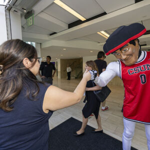 Matty the Matador gives a fist bump to a woman entering The Soraya.