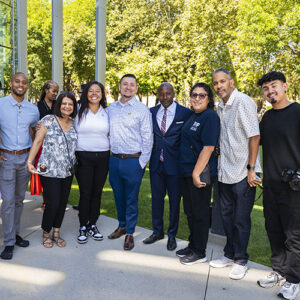 Faculty and staff members pose together for a photo outside The Soraya.