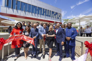 Two people among a crowd of people cut the ribbon on a high-tech building at California State University, Northridge.