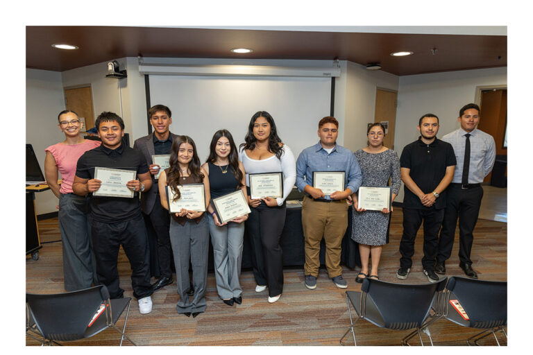 A group of high schoolers holding certificates and college staff stand for a group photo.