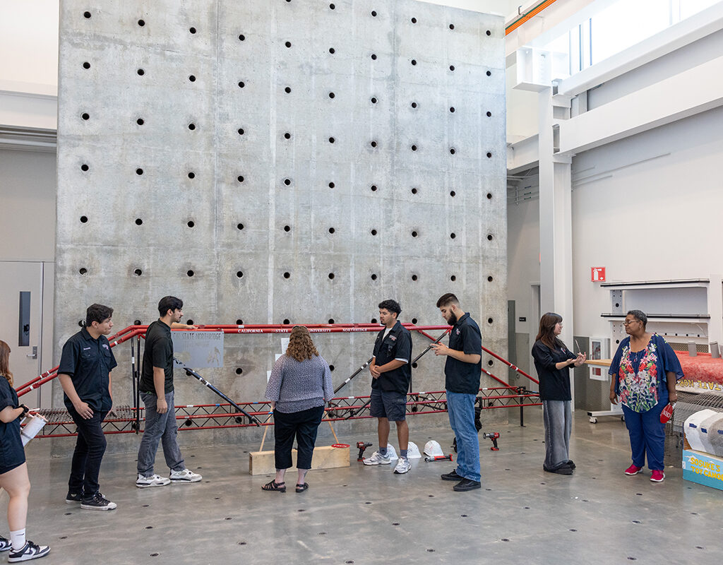 People stand in front of a 20-foot-tall reaction wall