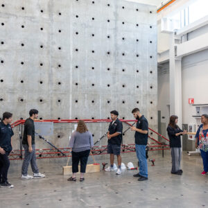 People stand in front of a 20-foot-tall reaction wall