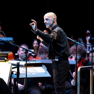 A man conducts a college orchestra during a concert at The Soraya.