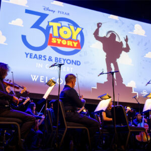 The CSUN Symphony orchestra performs in front of "Toy Story" 30th anniversary title screen.